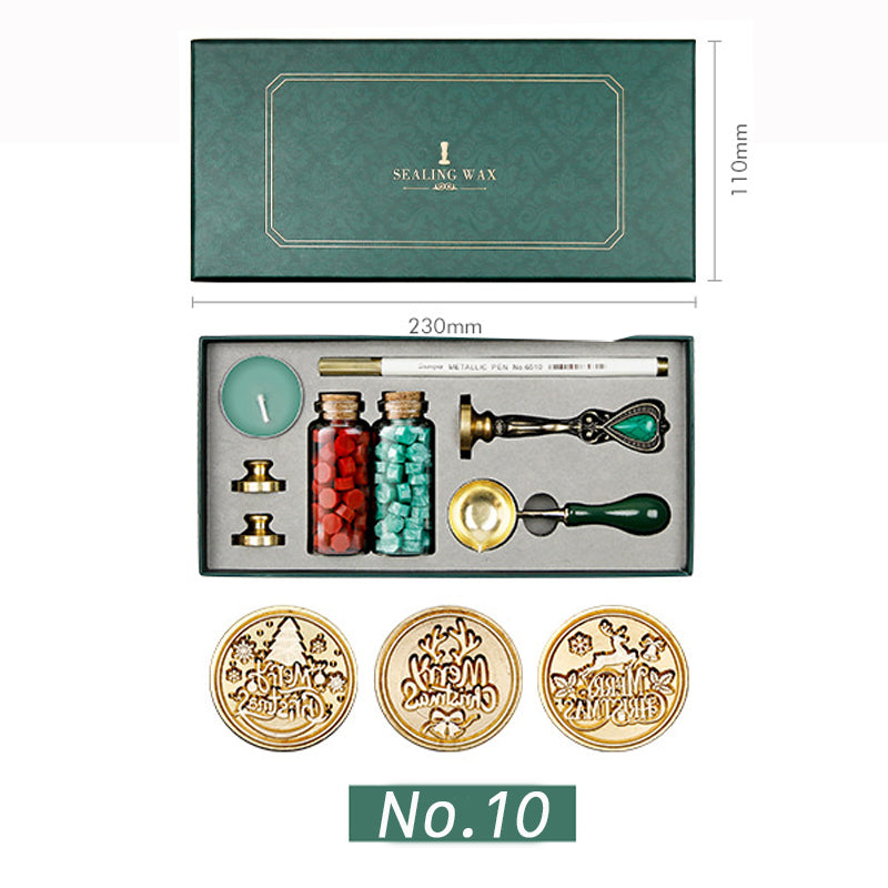 Wax seal kit with three Merry Christmas stamp heads, red and teal wax beads, spoon and candle in a green box