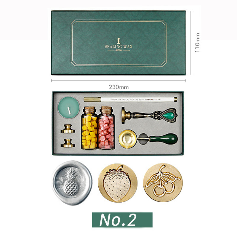 Wax seal kit with pineapple, strawberry and cherries stamp heads, yellow and pink wax beads in a green box