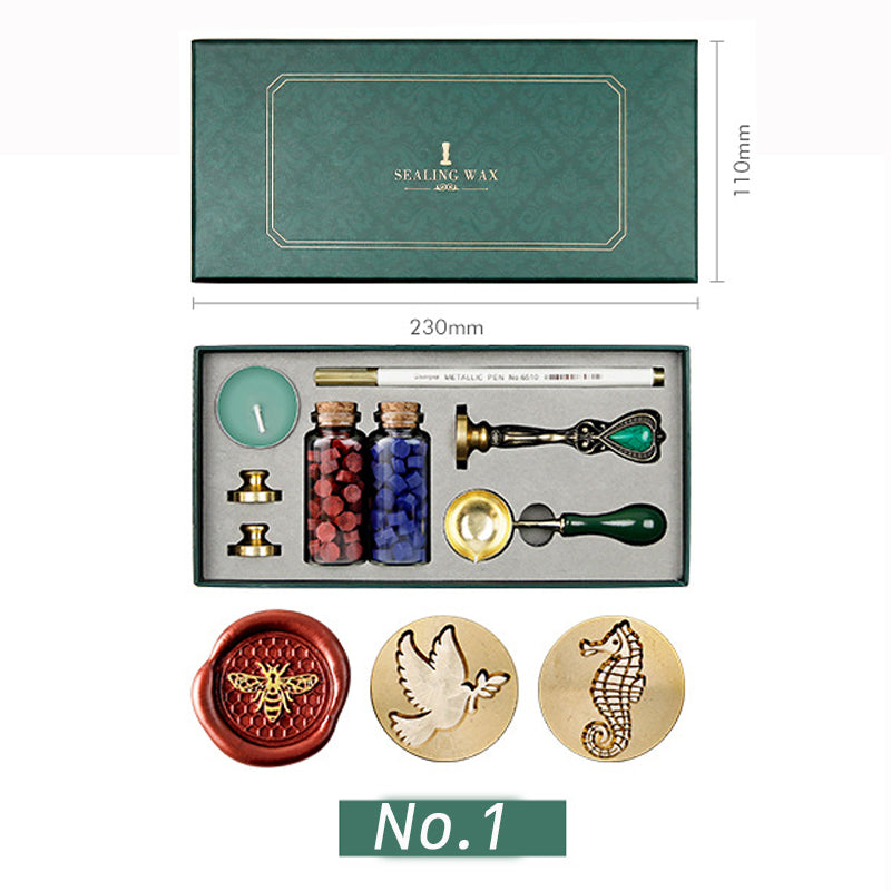 Wax seal kit with bee, dove and seahorse stamp heads, red and blue wax beads, spoon and candle in a green box