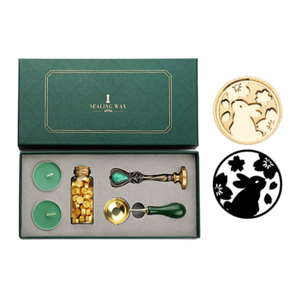 Wax seal set with rabbit and blossoms stamp, gold wax beads, two tea lights and melting spoon in a green box