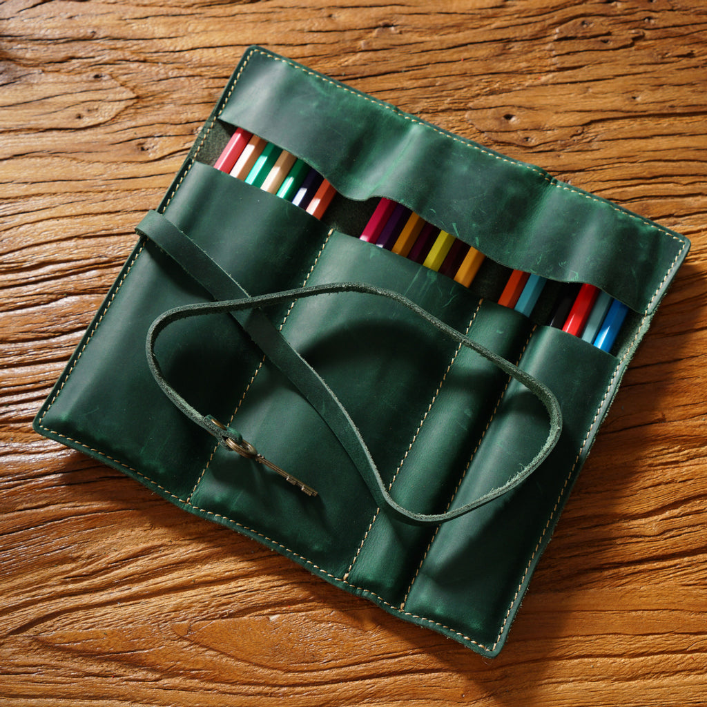 Leather pen roll opened flat to show its four slots, shown in green