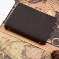 A5 leather ring binder journal in dark brown, closed, on a vintage-style map print