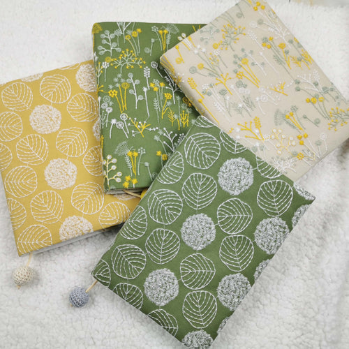 Four embroidery-style fabric book jackets in yellow, green and beige designs with crocheted bead cords