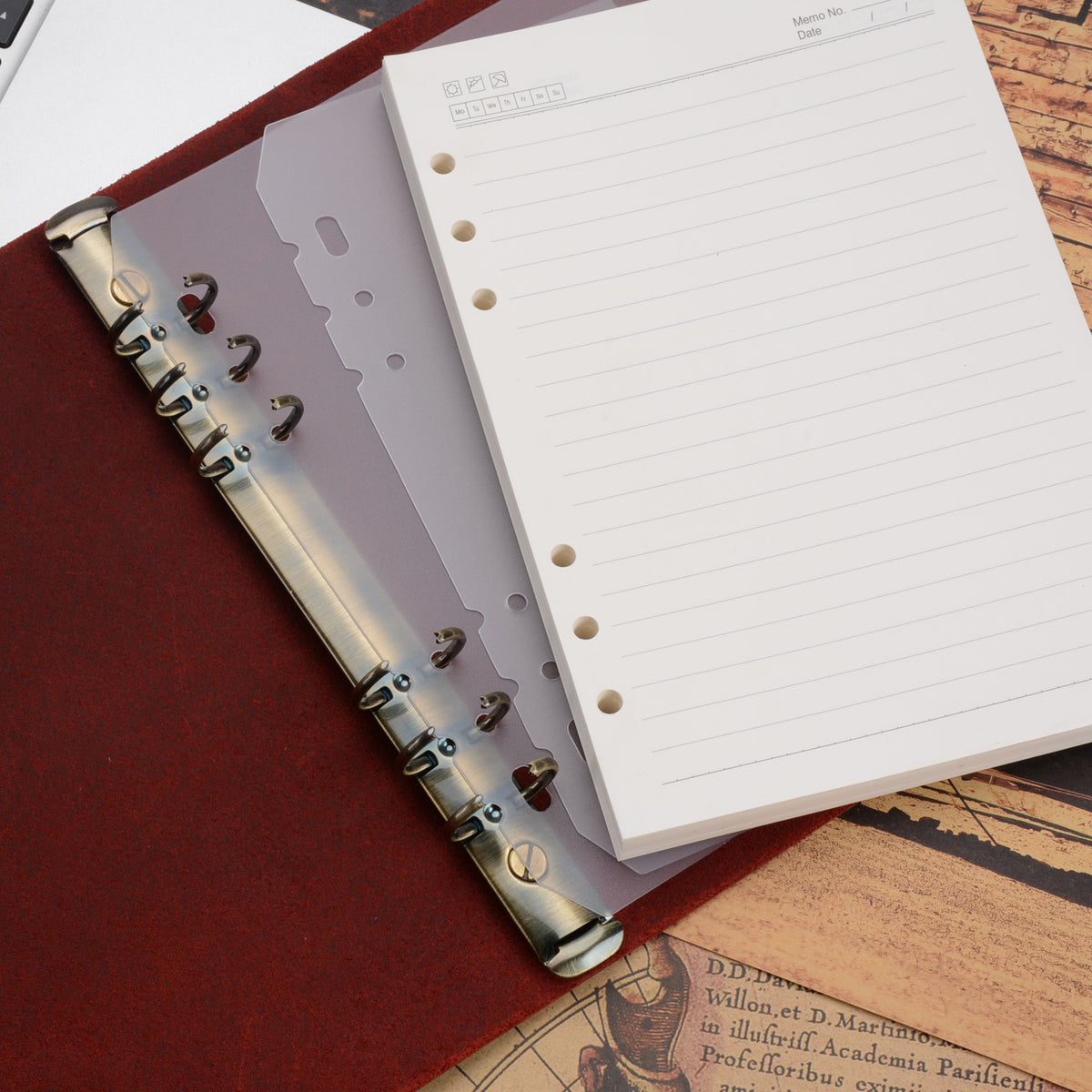 Open A5 binder journal showing the six metal rings, lined paper and a clear divider